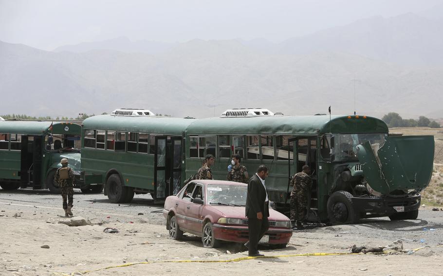 Afghan security forces inspect the site of a suicide attack on the outskirts of Kabul, Afghanistan, Thursday, June 30, 2016. An Afghan official said that two suicide bombers attacked a bus carrying trainee policemen. 