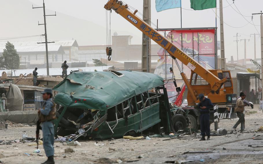Afghan security forces inspect the site of a suicide attack on the outskirts of Kabul, Afghanistan, Thursday, June 30, 2016. A twin suicide attack on a convoy of buses carrying police cadets killed 37 people and wounded 40 others on Thursday, an Afghan official said. 