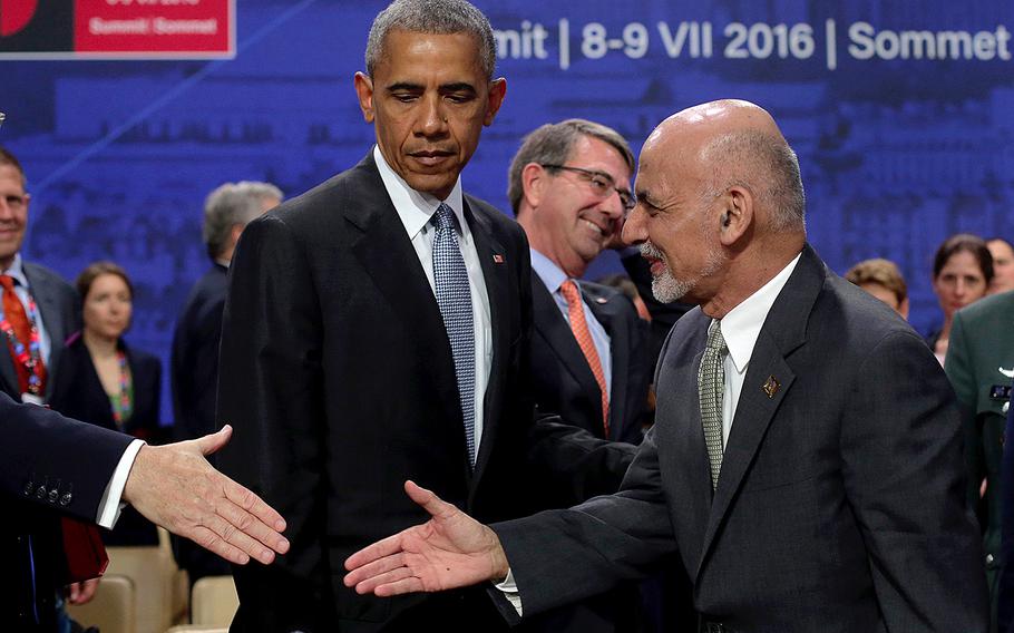 U.S. President Barack Obama watches Afghan President Ashraf Ghani shake hands with an official at the NATO summit in Warsaw, Poland, Saturday, July 9, 2016. 