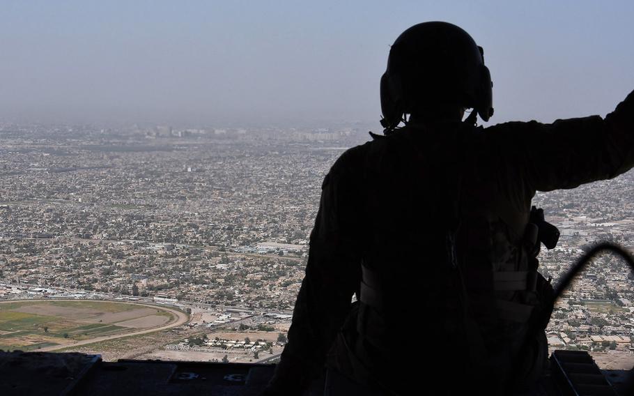 A U.S. soldier looks out over Baghdad, Iraq from the back of a CH-47 Chinook helicopter on Monday, July, 11, 2016.