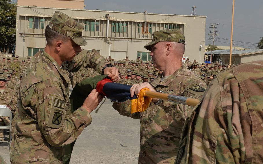 Command Sgt. Maj. Charles Albertson, left, and Maj. Gen. Jeffrey Bannister, right, case the 10th Mountain Division's colors during a transfer of authority ceremony for the national support element of U.S. Forces-Afghanistan at Bagram Air Field on Tuesday, Sept. 13, 2016.