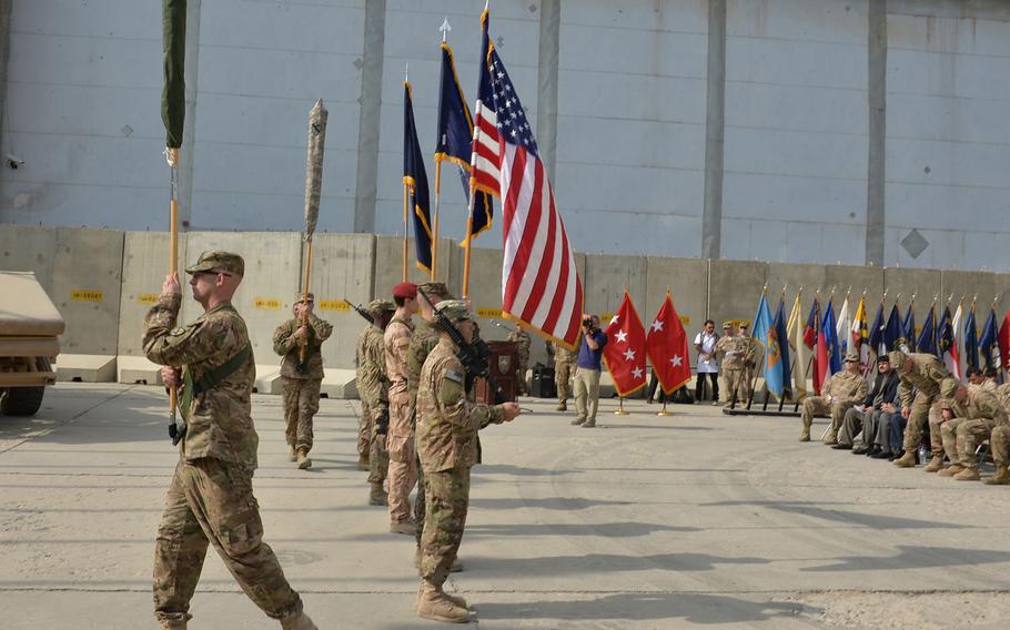 A flag bearer marches off the 10th Mountain Division's cased colors as a second flag bearer marches on the 1st Cavalry Division's cased colors during a transfer of authority ceremony for U.S. Forces-Afghanistan's support element at Bagram Air Field on Tuesday, Sept. 13, 2016.