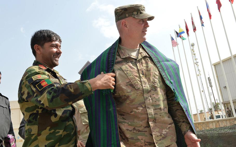 An Afghan lieutenant colonel drapes a traditional robe over the shoulders of Maj. Gen. Jeffrey Bannister, commander of the Army's 10th Mountain Division, after a transfer of authority ceremony at Bagram Air Field on Sept. 13, 2016. Bannister was the outgoing commander of U.S. Forces-Afghanistan's support element and worked closely with Afghan counterparts in the military and government.