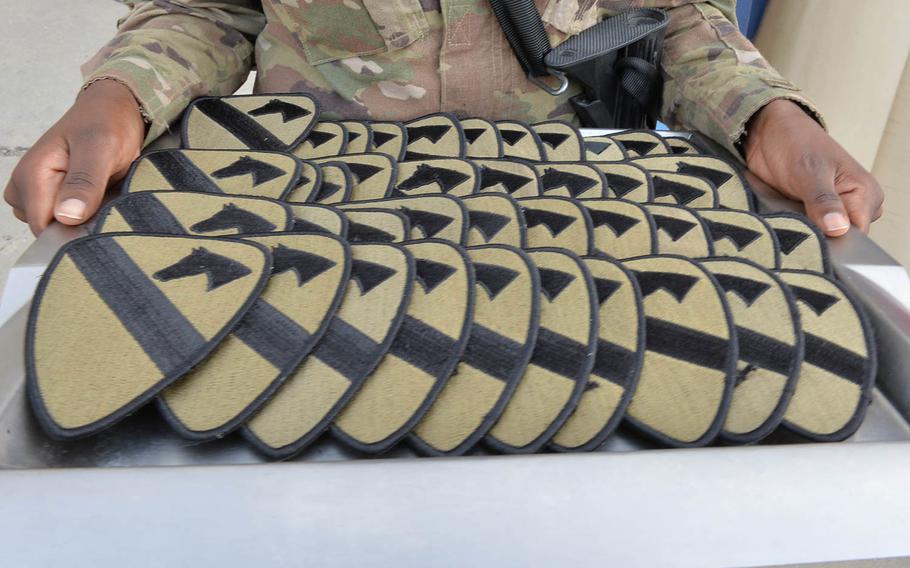 A soldier holds a tray full of 1st Cavalry Division combat patches during a ceremony at Bagram Air Field on Tuesday, Sept. 13, 2016, celebrating the division's 95th birthday. Soldiers deployed with the division, as well as counterparts in other services and coalition forces, received the distinctive patch, the largest in the Army, to signify their wartime service.

