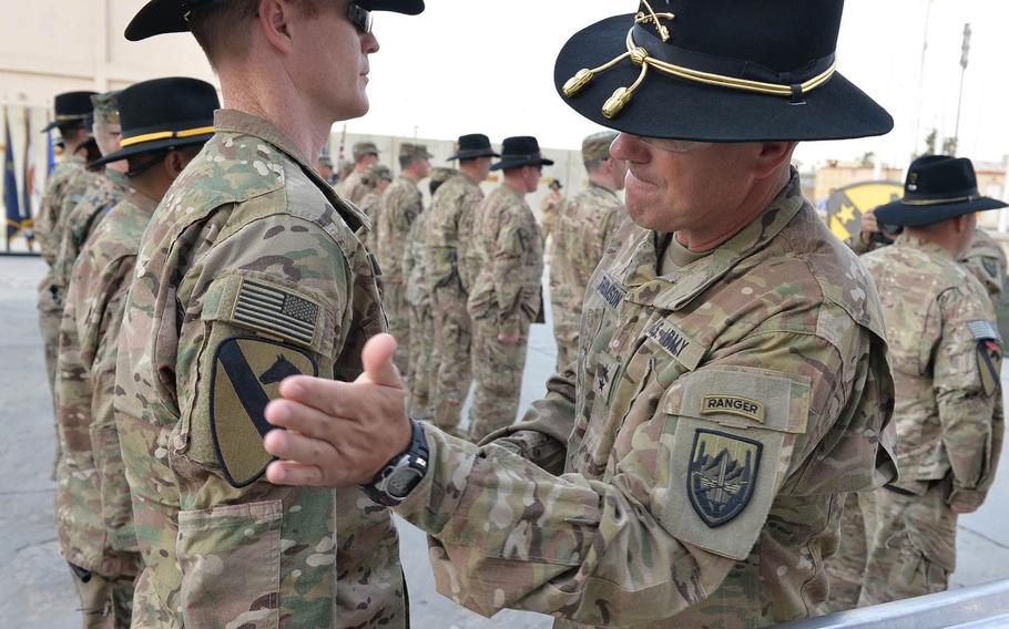 Maj. J.D. Carlton receives the 1st Cavalry Division combat patch from Maj. Gen. John 'J.T.' Thomson during a ceremony celebrating the division's 95th birthday at Bagram Air Field on Tuesday, Sept. 13, 2016.

