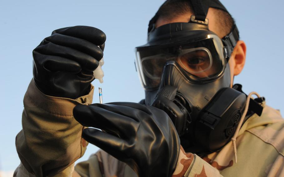 An airman tests water for chemical agents during an exercise. 