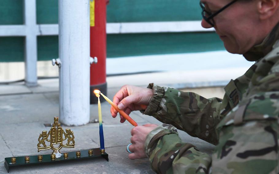 Navy Lt. Lauren Sucher, of Annapolis, Md., lights a menorah on the first night of Hanukkah, 2016 in Kabul, Afghanistan.