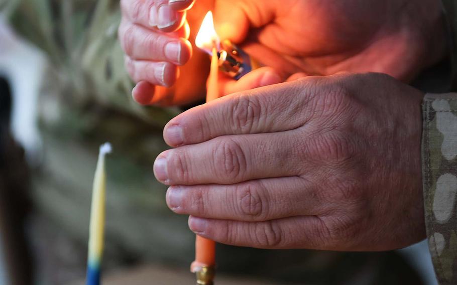 Navy Lt. Lauren Sucher, of Annapolis, Md., and Navy Chief Petty Officer Kent Frosch, of Washington, D.C., light a menorah on the first night of Hanukkah, 2016 in Kabul, Afghanistan.