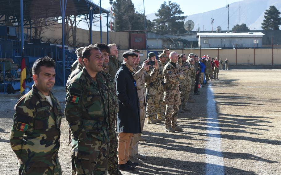 Soldiers from the Afghan Army as well as NATO coalition partners Australia, Romania, Italy, Georgia, Romania, Belgium, and Czech Republic watch the Christmas Day soccer match Sunday from the sidelines at Resolute Support headquarters in Kabul.