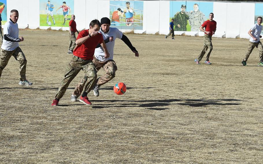 British and German troops vie for the ball during a Christmas Day soccer match Sunday at Resolute Support headquarters in Kabul commemorating the 1914 Christmas Truce.
