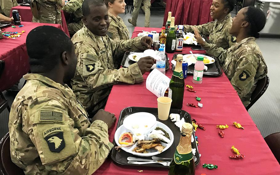 Soldiers of the 101st Airborne Division's 2nd Brigade Combat Team enjoy a holiday meal at the Combined Joint Operations Center at the Irbil International Airport in Iraq on Sunday, Dec. 25, 2016. On the left, front to back, are Spec. Kwame Osei, Staff Sgt. Jonathan Ingram, and Sgt. Brooke Dent. On the right, front to back, are Sgt. Dhane Dingle and Private 1st Class Neesy Sanders.