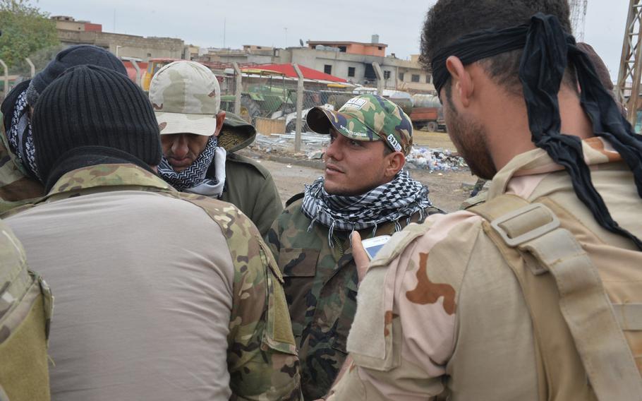 A member of a Christian militia, called Nineveh Plain Units, wears what appears to be a 5.11 Tactical baseball cap while warming himself alongside fellow militia members in Qaraqosh, Iraq, on Dec. 17, 2016. It can be difficult to tell some 5.11 Tactical fakes, which are plentiful in Iraq, from the authentic gear.



