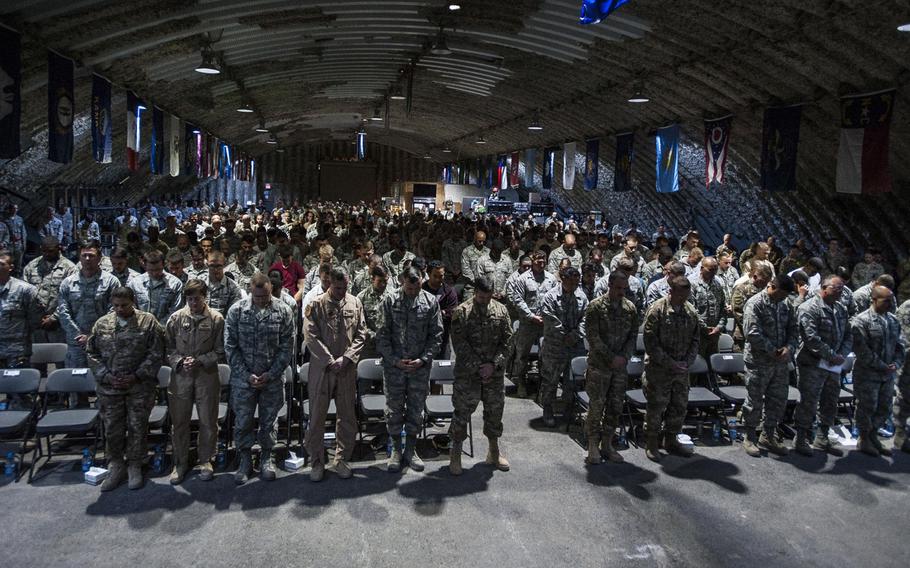 Airmen of the 332nd Air Expeditionary Wing bow their heads for an invocation during a fallen warrior memorial ceremony Mar. 23, 2017, in Southwest Asia. The ceremony was held for Staff Sgt. Alexandria Mae Morrow.