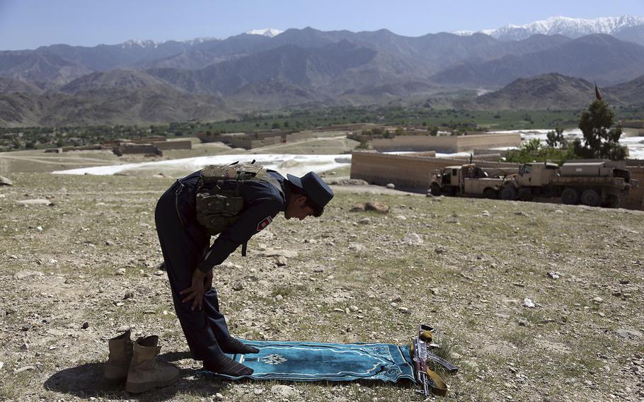 An Afghan security personnel prays in Pandola village near the site of a U.S. bombing in the Achin district of Jalalabad, east of Kabul, Afghanistan, Friday, April 14, 2017.