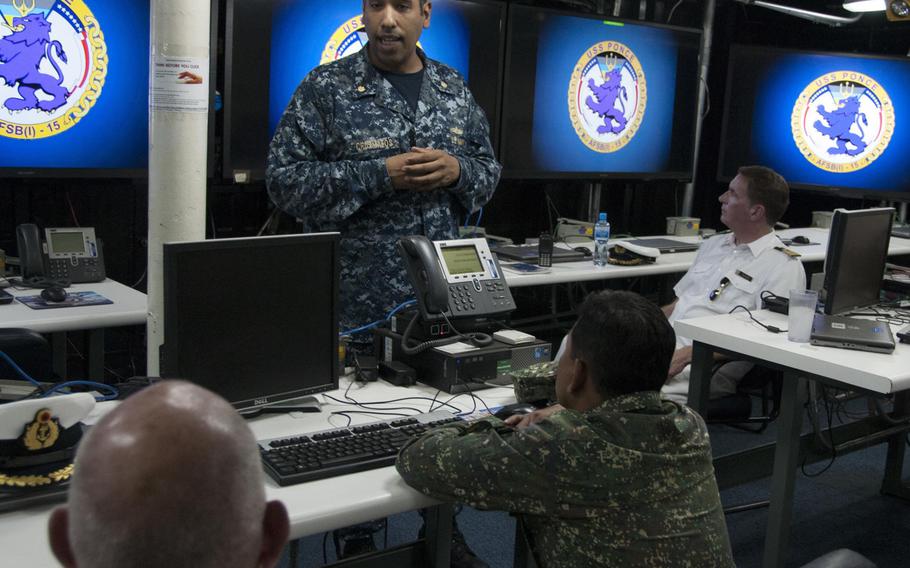 Lt. Cmdr. Edward Cruzmatos discusses the capabilities of Afloat Forward Staging Base (Interim) USS Ponce with participants of the International Maritime Exercise 2017.