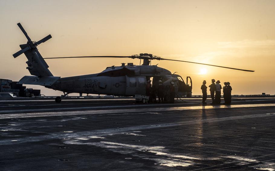 Flight deck crew onboard the aircraft carrier USS George H.W. Bush check a helicopter prior to take off in the Persian Gulf on April 20, 2017.