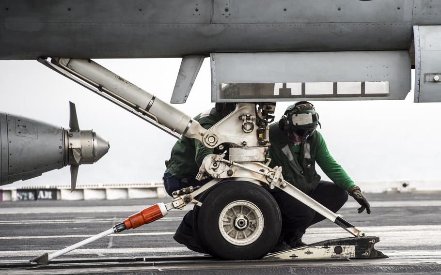 Catapult personnel ensure the catapult is correctly connected to an aircraft prior to launching off of the flight deck of aircraft carrier USS George H.W. Bush in the Persian Gulf on April 19, 2017.
