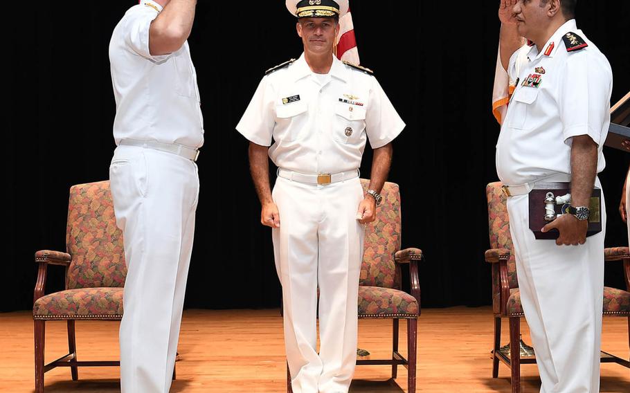 U.S. Navy Vice Adm. John Aquilino, commander of the Combined Maritime Forces, center, presides while Turkish Naval Forces Rear Adm. Emre Sezenler, left, turns over command of Combined Task Force 151 to Royal Bahrain Navy Capt. Yusuf Almannaei, right, at Naval Support Activity Bahrain, Nov. 2, 2017. 
