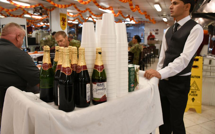 A waiter serves sparkling grape juice during Thanksgiving dinner at NATO's Resolute Support headquarters in Kabul, Afghanistan, on Thursday, Nov. 23, 2017. Alcohol is prohibited on the base. 

