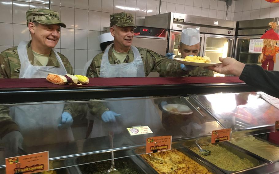 Vice Adm. Luke McCollum, chief of Navy Reserve and commander of the Navy Reserve Force, left, and Navy Rear Adm. Phillip Lee Jr. serve Thanksgiving dinner to troops and contractors at NATO's Resolute Support headquarters in Kabul, Afghanistan, on Thursday, Nov. 23, 2017.

