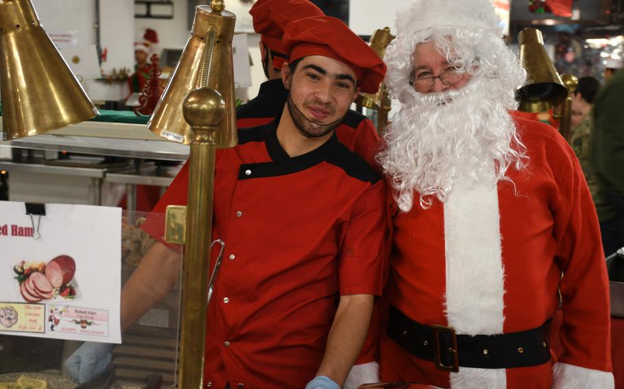 Pictured here during Christmas Day dinner on Monday, Dec. 25, 2017, Santa poses with Said Ashraf, one of about 130 dining facility workers who spent weeks preparing Christmas dinner for about 1,500 troops and other personnel at Resolute Support headquarters in Kabul, Afghanistan.
