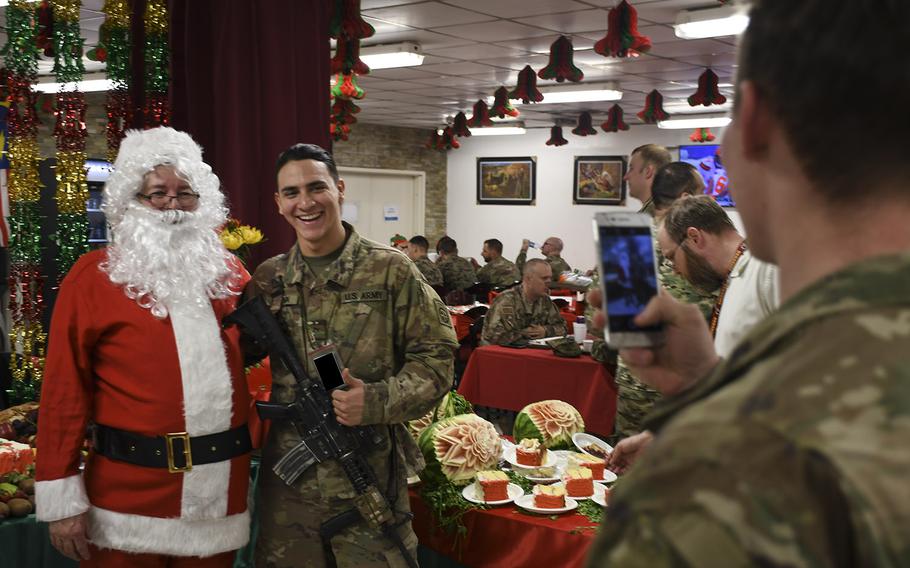 Pvt. Class Chris Kindon, a guardian angel with the 82nd Airborne Division, poses for a cell phone photo with Santa during Christmas Day dinner at Resolute Support headquarters in Kabul, Afghanistan on Monday, Dec. 25, 2017. Kingdon, who spent Christmas in Afghanistan, was looking forward to leaving the country shortly after the holiday.
