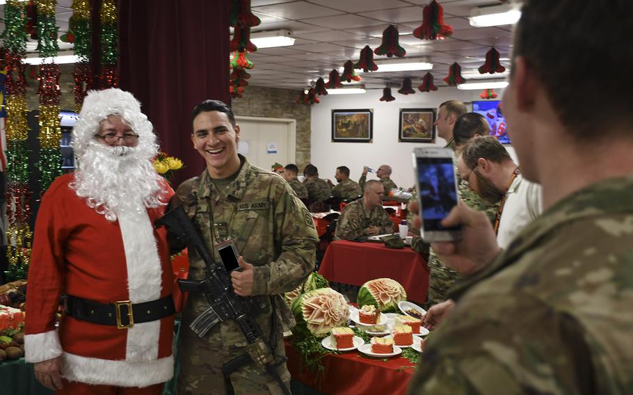 Pvt. Class Chris Kindon, a guardian angel with the 82nd Airborne Division, poses for a cell phone photo with Santa during Christmas Day dinner at Resolute Support headquarters in Kabul, Afghanistan on Monday, Dec. 25, 2017. Kingdon, who spent Christmas in Afghanistan, was looking forward to leaving the country shortly after the holiday.
