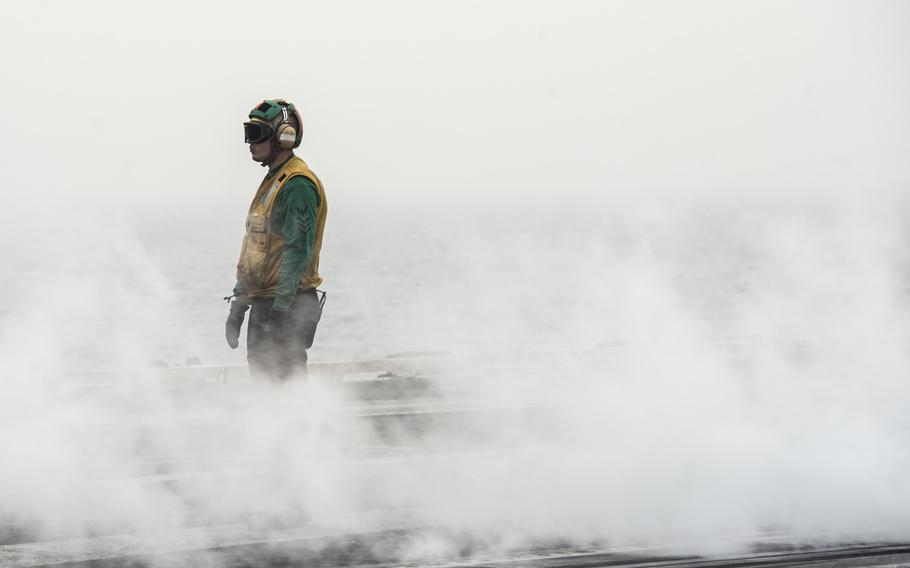 A flight deck crew member watches to ensure the catapult moves into the correct position to launch an aircraft off the flight deck of the aircraft carrier USS George H.W. Bush in the Persian Gulf April 19, 2017. 

