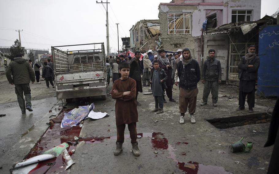 Residents walk through the site of a suicide attack in Kabul, Afghanistan, Friday, March 2, 2018. A large explosion in the eastern part of the Afghan capital on Friday morning killed at least one and wounded others officials said. 