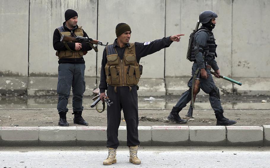 Security forces inspect the site of a suicide attack in Kabul, Afghanistan, Friday, March 2, 2018. 