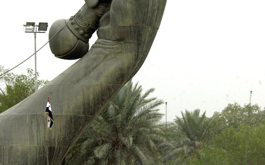 Soldiers approach Saddam Hussein's famed Hands of Victory monument in Baghdad in April 2003. The monument has two sets of crossed swords marking the entrance and exit to a massive military parade ground. The arches were built to celebrate "victory" over Iran. According to Globalsecurity.org, the metal used to make the swords came from melted down Iraqi weapons from the Iran-Iraq war. Helmets thrown at the base of each sword are Iranian, collected on battlefields; and the hands are replicas of Hussein's. 
