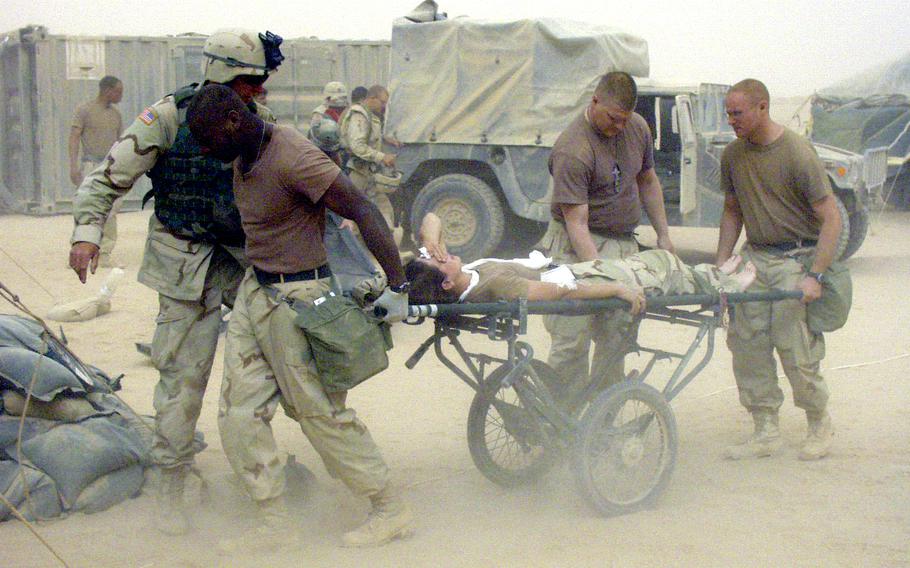 Medics wheel an injured soldier, just unloaded from a Black Hawk medevac helicopter, into the 212th Mobile Army Surgical Hospital during a sandstorm in central Iraq in April 2003.
