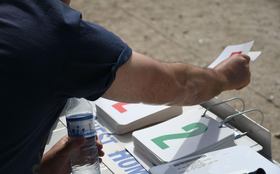 An official changes the score after a Georgian team scores against a team from Uganda in the Bagram World Cup soccer tournament at Bagram Air Field, Afghanistan, on Friday, March 23, 2018.
