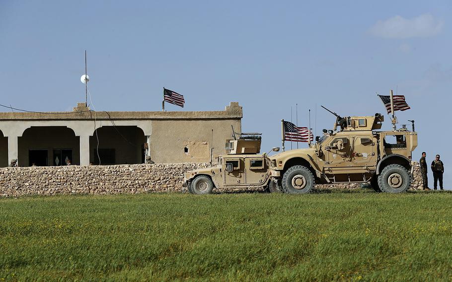 U.S. soldiers sit inside a house-turned-into-outpost at left on a road leading to a front line between U.S-backed Syrian Manbij Military Council fighters and Turkish-backed fighters, at Halawanji village, north of Manbij town, Syria, on Thursday March 29, 2018.
