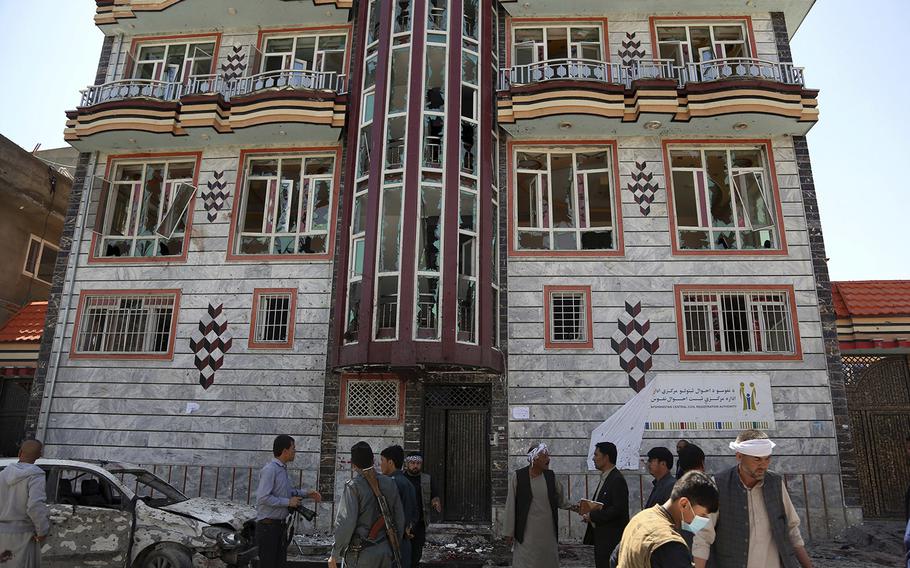 People gather outside a voter registration center which was attacked by a suicide bomber in Kabul, Afghanistan, Sunday, April 22, 2018.