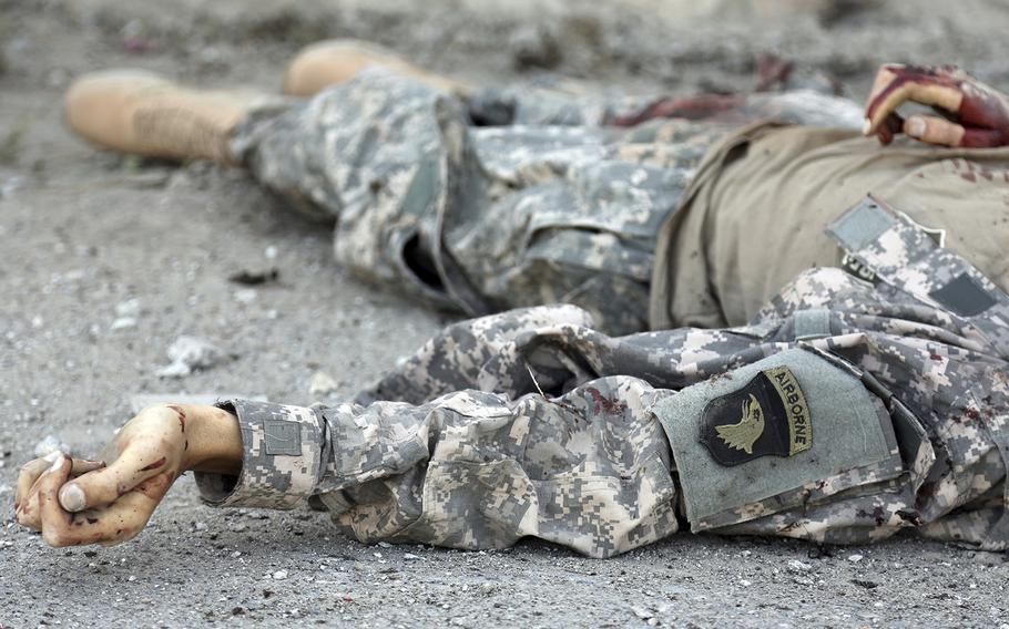 The body of a militant fighter, wearing a U.S. military uniform, lies inside the Interior Ministry building after a deadly attack, in Kabul, Afghanistan, Wednesday, May 30, 2018.