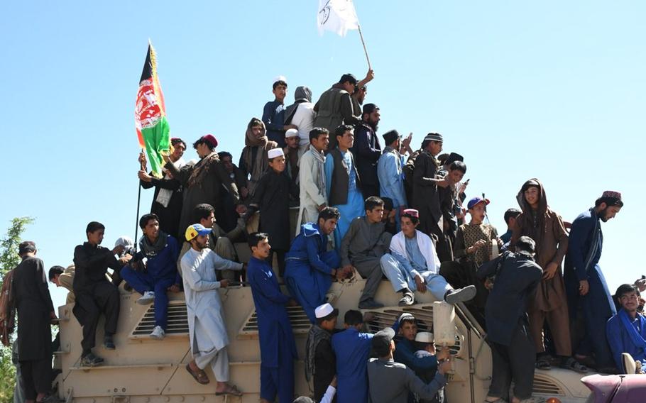 Men crowd atop an Afghan army mine-resistant ambush protected vehicle waving the Afghan and Taliban flags on Saturday, June 16, 2018, in Logar province's capital of Pul-e-Alam on the second day of jubilant gatherings to celebrate cease-fires.  Later in the day, a suicide bomber blew himself up in eastern Afghanistan killing 21 people and wounding another 41, said the Nangarhar provincial Police Chief. Most of the dead and wounded were believed to be Taliban.


