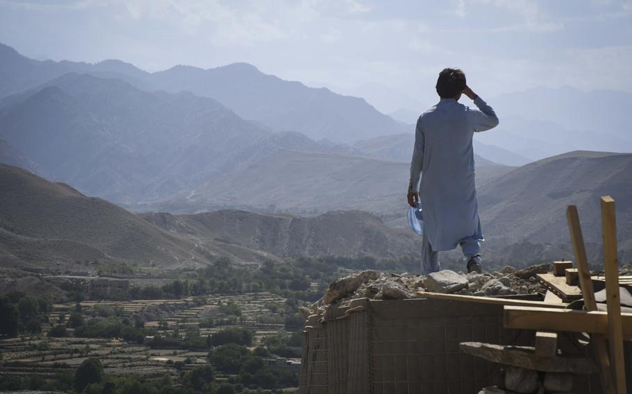 Eman, 20, a member of the Afghan Local Police, watches over a key valley from his checkpoint in Deh Bala district in Nangarhar province, Afghanistan, on Saturday,  July 7, 2018. 