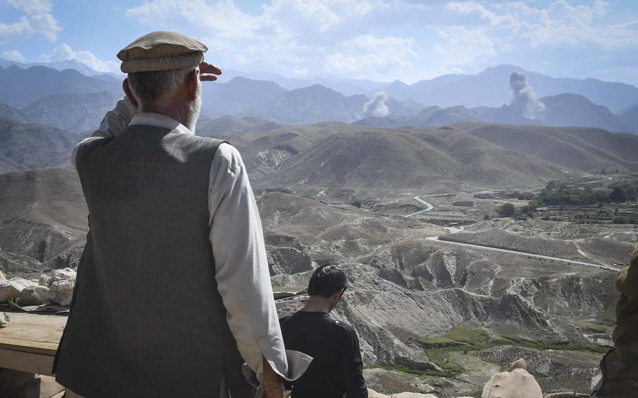 A member of the Afghan Local Police watches the aftermath of bombings by American F-16 fighter-bombers against a key valley in Deh Bala district in Nangarhar province, Afghanistan, Saturday,  July 7, 2018.
