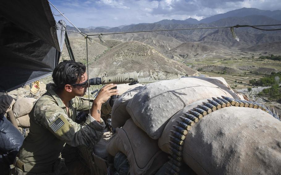 A Special Forces soldier peers through a scope while manning Observation Post Krakken, a checkpoint overlooking a key valley in Deh Bala district in Nangarhar province on Saturday, July 7, 2018. 