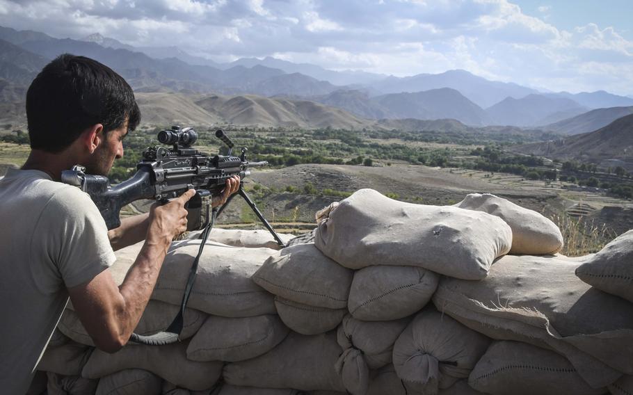 Khairullah, 30, an Afghan commando, sights an M-249 light machine gun at Observation Post Krakken, a checkpoint overlooking a key valley in Deh Bala district in Nangarhar province on Saturday, July 7, 2018.

