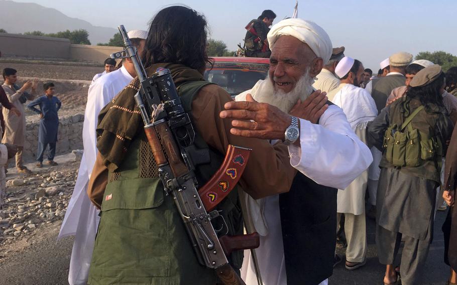 In this June 16, 2018 file photo, Taliban fighters gather with residents to celebrate a three-day cease fire marking the Islamic holiday of Eid al-Fitr, in Nangarhar province, east of Kabul, Afghanistan. On Sunday, Aug. 19, 2018, Afghan President Ashraf Ghani announced a conditional cease-fire with Taliban insurgents for the duration of the Eid al-Adha holiday. Ghani made the announcement Sunday during celebrations of the 99th anniversary of Afghanistan's independence.
