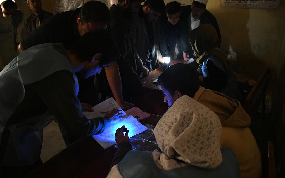 Kabul voters are identified before casting their ballots at a polling center in the Shahr-e-Naw area of Kabul on Saturday, Oct. 20, 2018. 