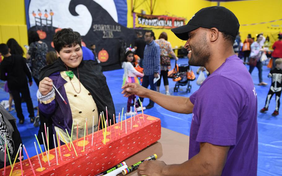 A volunteer and child play a game at the Bahrain School’s Spooktakular event on Friday, Oct. 26, 2018.
