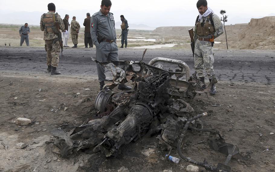 Afghan security forces gather at the site of Monday's suicide attack near the Bagram Air Field, north of Kabul, Afghanistan, Tuesday, April 9, 2019. Three American servicemembers and a U.S. contractor were killed when their convoy hit a roadside bomb on Monday near the base.