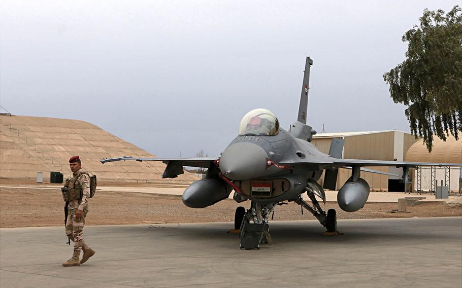 An Iraqi soldier stands guard near a U.S.-made Iraqi Air Force F-16 fighter jet at Balad Air Base, Iraq, on Tuesday, Feb. 13, 2018. 