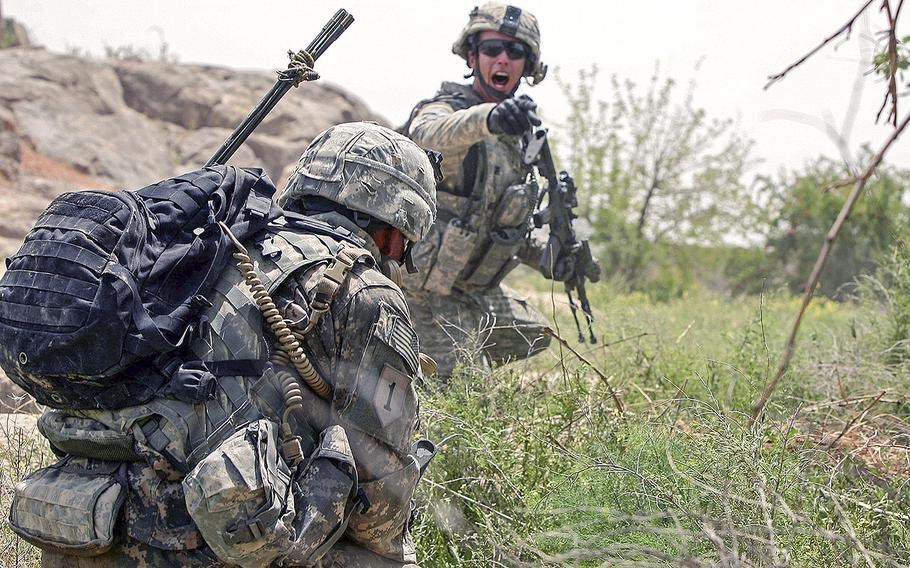In a April 27, 2009 file photo, Staff Sgt. Dylan Lugibihl, 24, of Napoleon, Ohio, with Company A, 2nd Battalion, 2nd Infantry Regiment, shouts orders during a firefight with Taliban insurgents near the village of Zangabad  in Kanadahar province, Afghanistan.