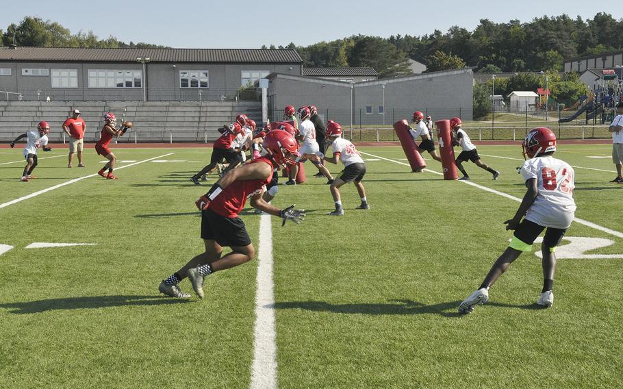 Head coach Robert Allen watches over a huddle during a preseason Kaiserslautern Raiders football practice Friday, Aug. 23, 2019, at Kaiserslautern, Germany.
