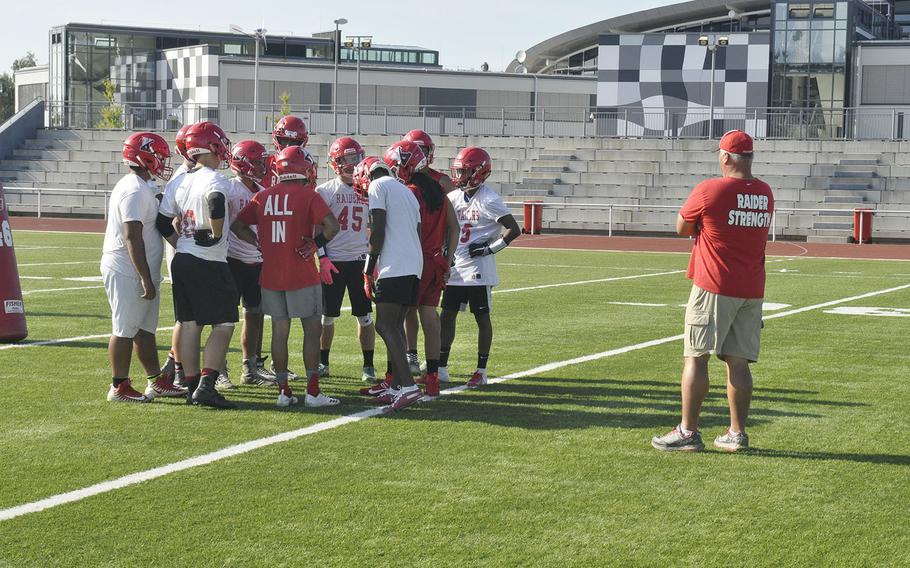 Head coach Robert Allen watches over a huddle during a preseason Kaiserslautern Raiders football practice Friday, Aug. 23, 2019, at Kaiserslautern, Germany.