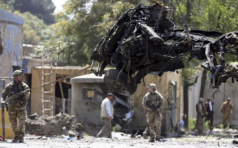 Resolute Support forces remove a damaged vehicle after a car bomb explosion in Kabul, Afghanistan, Thursday, Sept. 5, 2019.